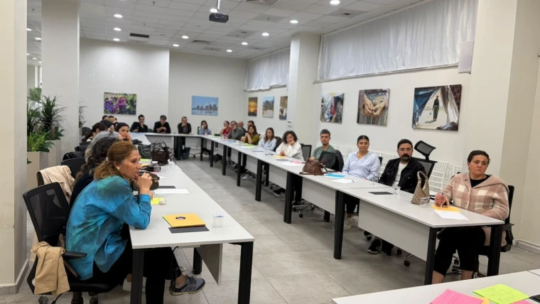 Kayapınar'daki akran zorbalığı eğitiminde masada oturan iki uzman psikolog velilere sunum yapıyor