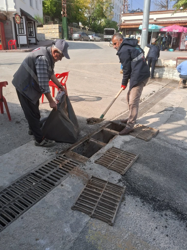 Eğil Belediyesi ekipleri cadde kenarındaki yağmur suyu ızgarasını temizliyor